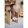 Nena asseguda en cadira Montessori